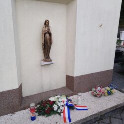 Položeno cvijeće i zapaljene svijeće na centralnom križu mjesnog groblja